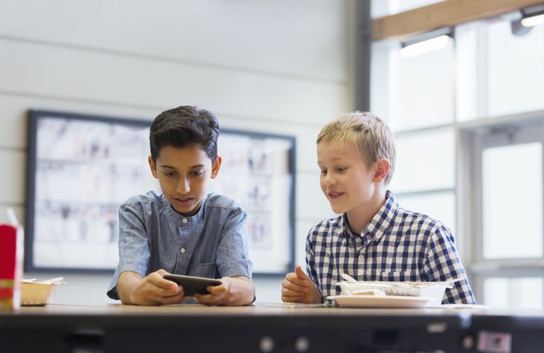 两个男孩在学校食堂看手机