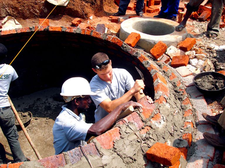 军校学员伊森·德沃特与乌干达建筑工人一起用砖块和砂浆建造了一个沼气池圆顶