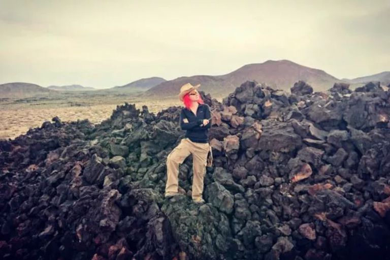 Jess Phoenix在一个块熔岩流动的中间在加利福尼亚。“class=